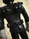 Rear view of the figure showing the same molded copyright text: “© 石森プロ 毎日放送 東映.” The figure’s black suit, white gloves, and belt are visible. The sculpted back and shoulder details are consistent with vintage sofubi styling.