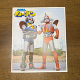 Two colorful tokusatsu-style superheroes shake hands in a park setting, labeled “Electromagnetic Warrior Chūgōrin” in Japanese Angle 1.
