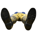 Close-up view of the underside of the Armored Captain Gatezone sofubi figure from Kamen Rider Black RX (1988). The figure lies on its back with legs extended, revealing embossed text on the soles of its boots. The left boot reads “TAKARA 1985 JAPAN,” confirming the manufacturer and production origin, while the right boot displays “© H. T. / T. / B. R.,” indicating licensing details. These molded markings are essential for verifying authenticity and provenance among vintage tokusatsu collectors.