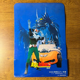 Japanese superhero poster featuring Chōjin Barom-1, a horned monster, and an orange car with winged emblem, placed on a wooden surface. Includes Japanese text and company info at the bottom.