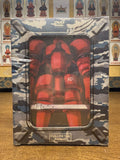 Sealed Japanese Full Metal Panic camouflage DVD box labeled "Full Metal Panic" on wooden table near Buddhist shrine statues. Plastic-wrapped front window displays large red Arm Slave robot marked A21. Camouflage design covers exterior.
