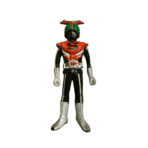 Close-up frontal view of the Kamen Rider Stronger figure in a neutral stance. The costume features red and black coloring with silver gloves and boots. The chest bears a black “S” emblem on red, and the belt has a starburst motif. The helmet is green with red antennae, evoking the classic tokusatsu aesthetic.