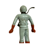 Rear view of the Kamen Rider X figure wearing a light gray suit with red gloves and boots. A black strap or ribbon extends from the neck. Molded Japanese copyright text on the back reads “© 石森プロ 毎日放送 東映,” confirming licensing by Ishimori Productions, Mainichi Broadcasting System, and Toei. The figure’s helmet and sculpted details are visible.