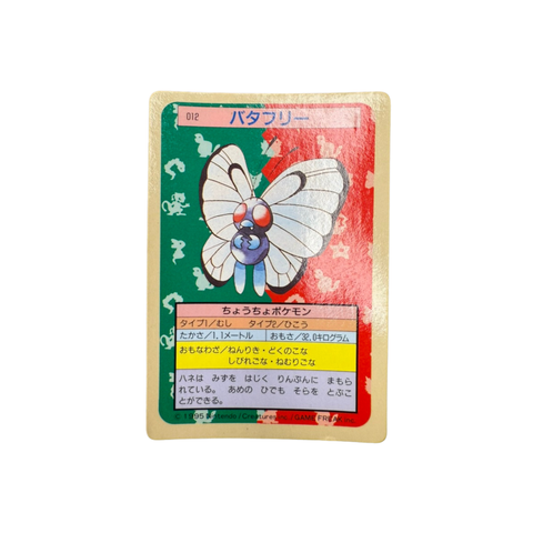  Japanese TopSun Pokémon card featuring Butterfree (バタフリー) placed on a wooden surface, with a colorful background showing silhouettes of other Pokémon. Includes Japanese text with Bug and Flying types, height and weight stats, and signature moves like “ねんりき” and “くさのこな.”