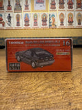 Boxed Tomica Premium TP16 Honda Ballade Sports CR-X die-cast model placed in front of a wall with Buddhist-style images. Packaging shows model number 16, scale 1/60, and suspension feature.