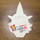 Cardboard mask of Henshin Ninja Arashi with horned design and Japanese promo text for Harisu Gum, placed on wood.
