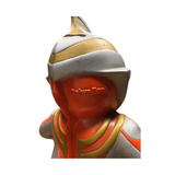 Back view of a stylized Ultraman Gaia piggy bank designed in a Daruma doll-inspired form. The figure features a rounded body with silver, orange, and gold coloring, and a helmeted head with a crest. Embossed text “Daruma” is visible on the back, blending traditional Japanese design with tokusatsu aesthetics. The figure’s cartoonish proportions and smooth finish suggest it’s a soft vinyl or molded plastic collectible from 1998.