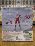Back of Ultraman Orb Origin The First S.H.Figuarts packaging placed in front of a wall with religious artwork. Highlights figure’s articulation, molding, and optional parts with Japanese descriptions and Bandai product details.