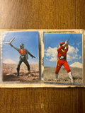 Two vintage tokusatsu trading cards in a plastic sleeve. The left card depicts a blue-helmeted hero standing in a dry grassy field holding a white bow or staff. The right card shows the same character in combat on a stone staircase, with a silver-costumed opponent lying defeated. The bottom of the right card includes “© 石森プロ・NET・東映,” confirming its connection to Himitsu Sentai Goranger. The cards reflect classic Japanese superhero action and dramatic outdoor settings.