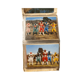 Two photographs in a plastic album sleeve featuring five costumed superheroes in dynamic team poses. The top photo shows characters in pink, green, red, blue, and yellow suits on a grassy field with buildings and trees. The bottom photo features a similar team in white, black, red, blue, and yellow suits, also posing outdoors. These images reflect classic Super Sentai team formations and costume design from the Goranger era.