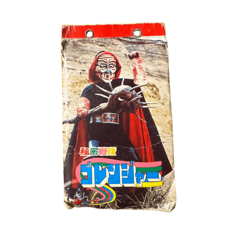 Vintage Japanese notebook cover featuring a villain from Himitsu Sentai Goranger. The character wears a red and black costume with a mask and holds a spiked weapon, standing in a rocky outdoor setting. The top of the notebook has a red border with metal-reinforced holes for binder use. Stylized Japanese text at the bottom reads “秘密戦隊ゴレンジャー,” confirming the item’s origin from the original Goranger series.