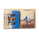 Two vintage trading cards in a plastic sleeve. The left card features four black-suited helmeted characters with weapons and one colorful character in a barren landscape. The right card shows a blue-suited hero kicking a soccer ball in a grassy field, wearing a red-and-white chest emblem and red leg patches. Partial copyright text “© TOEI NET” is visible, linking the cards to Himitsu Sentai Goranger and Toei’s tokusatsu productions.