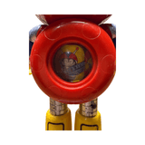Close-up of the Batten Robomaru GB-94 toy robot’s head and upper torso. The figure has a circular red helmet with a blue faceplate featuring large cartoon-style eyes with white pupils and black outlines. The arms are blue with silver joints, and a yellow element is partially visible on the right side. The design is playful and expressive, reflecting the character’s animated personality and child-friendly aesthetic.