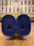 Close-up view of the underside of two blue plastic toy feet from the Batten Robomaru GB-94 figure. The left foot features Japanese embossed text reading “バッテン X © モグプロ フレーベル館,” indicating character and publisher licensing. The right foot displays the Popy logo with “1982 JAPAN” stamped below, confirming the toy’s origin and production year. Both feet are joined with visible screws, showcasing the figure’s vintage construction and authenticity markers.