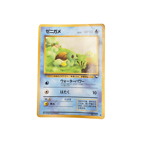 Japanese Pokémon card featuring Zenigame (Squirtle) in a grassy outdoor scene. The card has a yellow border and blue background, with 50 HP, two attacks—“ウォーターパワー” and “はたく”—and card number No.007. Illustrated by Kagemaru Himeno.